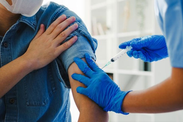 مرد در حال تزر یق واکسن دوز سوم یا بوستر بیماری کویید 19