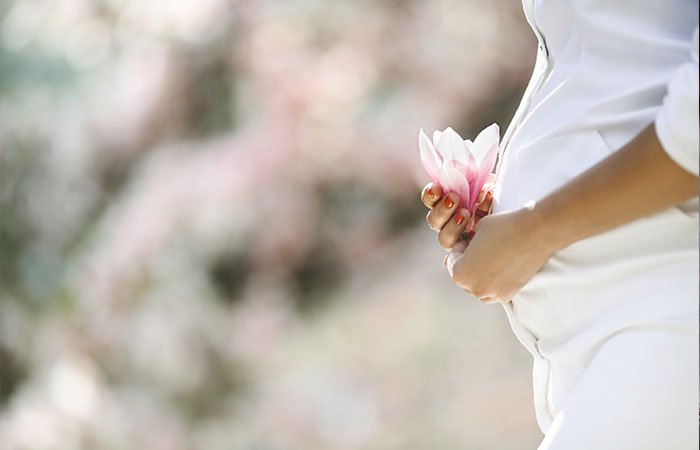 خانم باردار در لباس سفید گل در دست